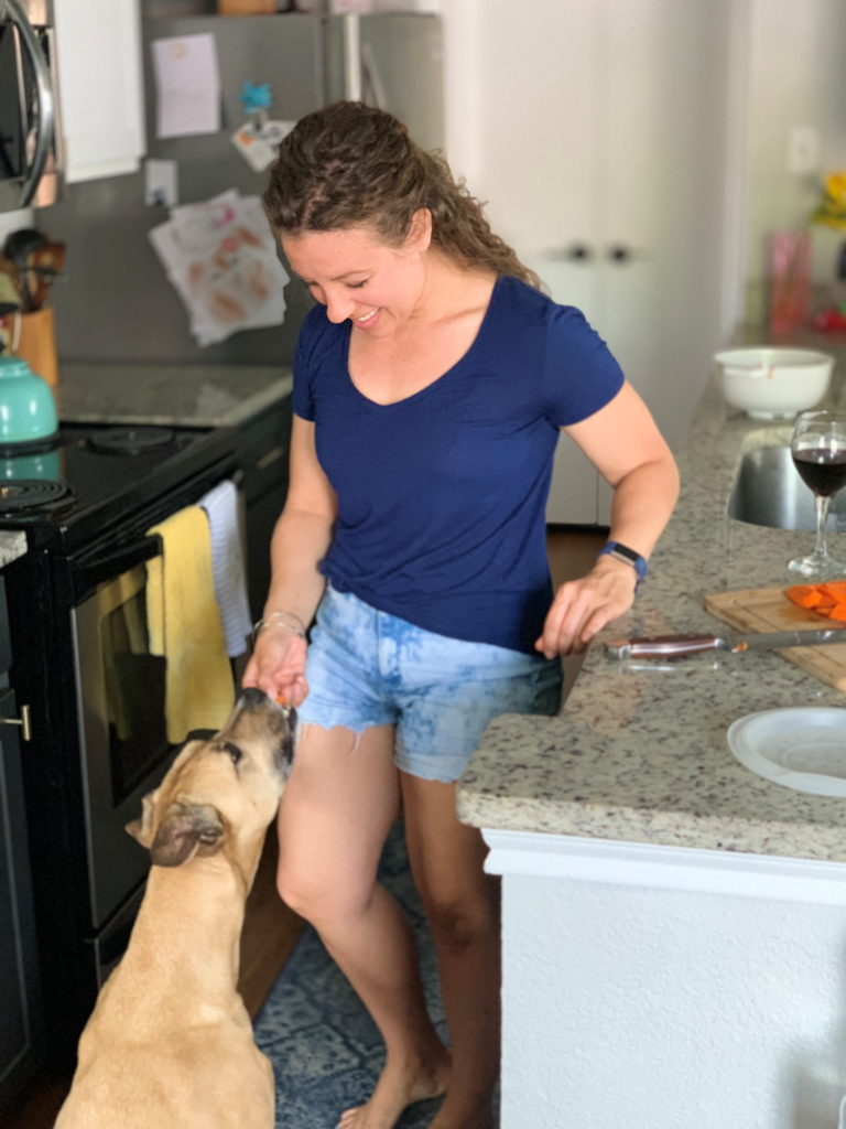 Coach Kristin feeds her adorable dog, Huck, some carrots.