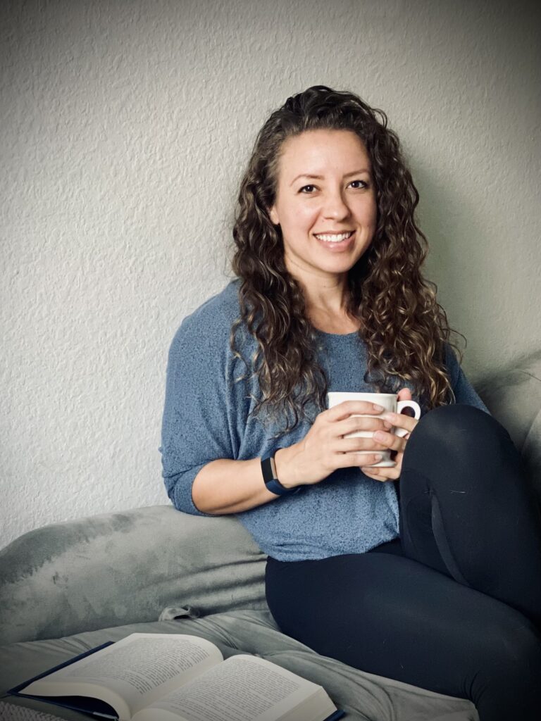 Coach Kristin lounges while holding a mug of coffee